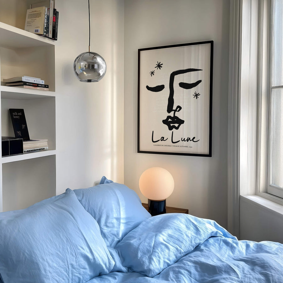 Abstract line art face with closed eyes in black ink. Poetic and feminine moon-themed wall art print with French quote overlay.
