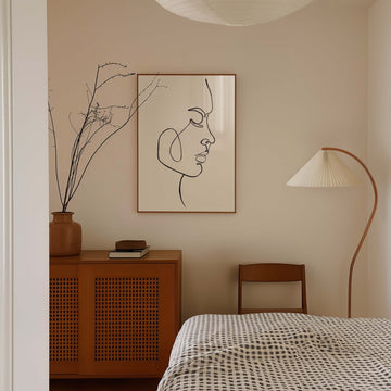 Minimalist black line art portrait of a woman in profile with soft features and elegant flowing lines. Modern abstract face print from EDGE Wall Art Australia.
