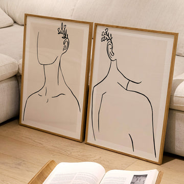 Set of two minimalist soulmate line art prints featuring faceless figures with floral details. Includes handwritten text “Written in Me” and “Etched in You.” Modern abstract wall art for couples or personal spaces.